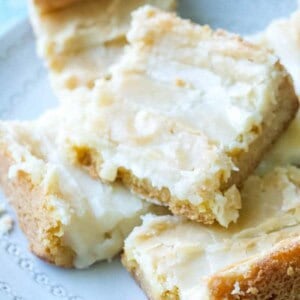 close up of ooey gooey cake bars stacked on a plate