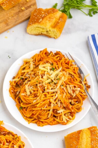top shot of spaghetti in red meat sauce on white plate