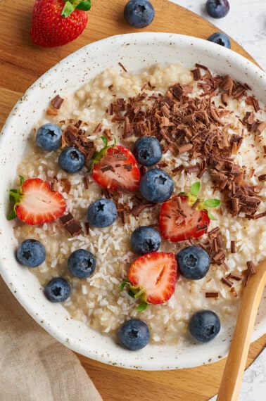 A bowl of Instant Pot oatmeal topped with blueberries, strawberries, and pecans.