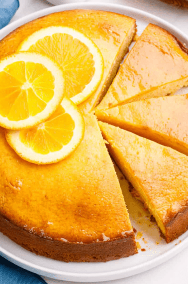 An orange cake with three slices cut.