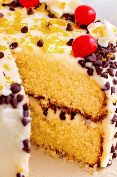 A layered cannoli cake with a slice missing.