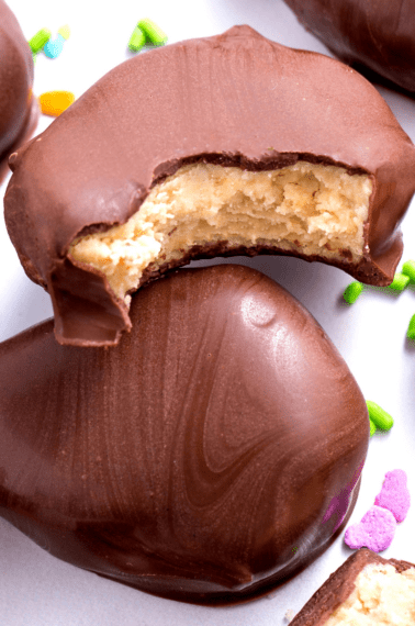 Two Reese's peanut butter eggs with one missing a bite.
