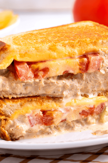 Two halves of a tuna melt sandwich stacked on top of each other.