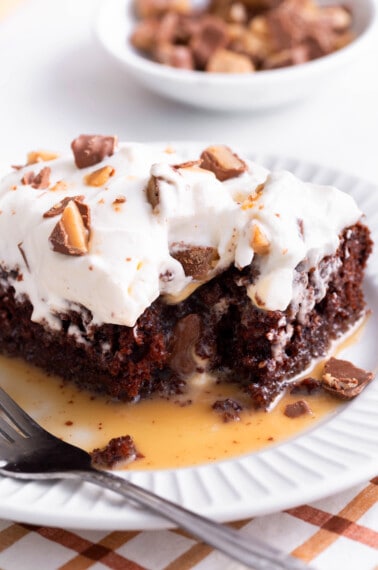 A slice of better than anything cake on a plate with a corner missing.