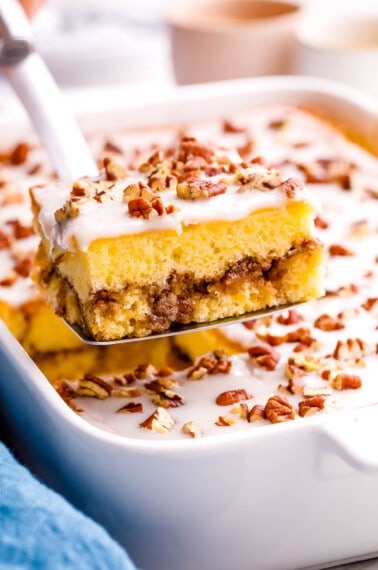A slice of honey bun cake being lifted from a dish.