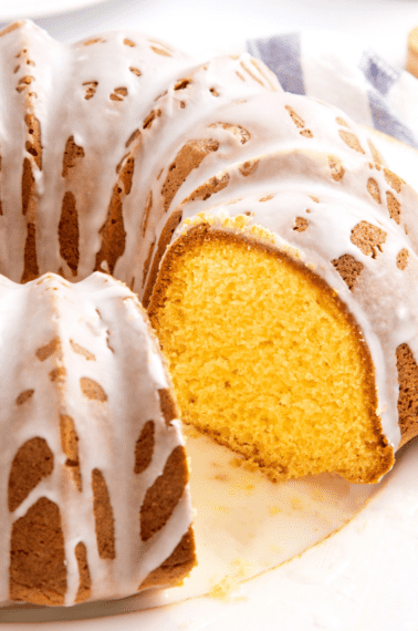 Pound cake topped with a glaze with a slice missing.