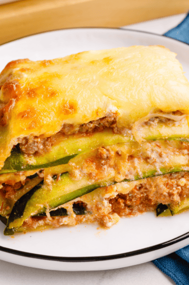 A square slice of zucchini lasagna on a plate.