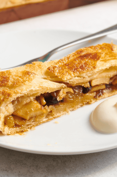 A slice of apple strudel on a plate.