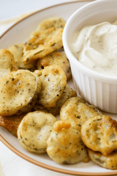 A plate of fried pickles with Ranch dipping sauce.
