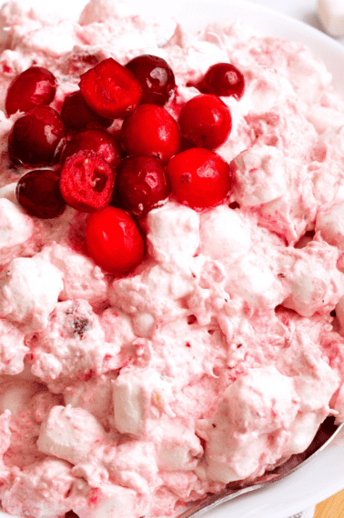 A bowl of cranberry fluff topped with whole cranberries.
