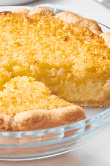 An old-fashioned coconut pie with a slice missing.