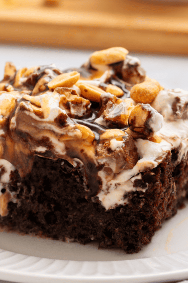 A slice of Snickers cake on a plate.