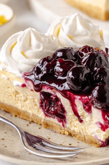 A slice of lemon blueberry cheesecake on a plate.
