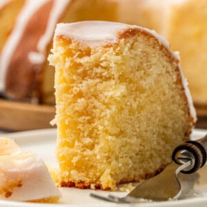 A slice of glazed 7UP Pound Cake on a plate with a fork.