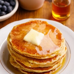 stack of pancakes with butter and syrup on top.