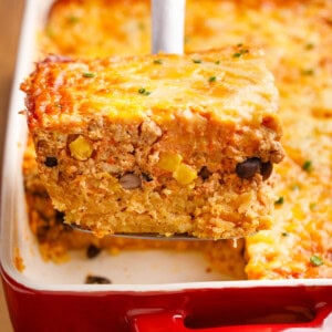 Mexican Breakfast Casserole on a serving spoon coming out of a baking dish.