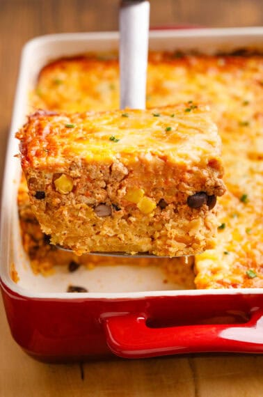 Mexican Breakfast Casserole on a serving spoon coming out of a baking dish.