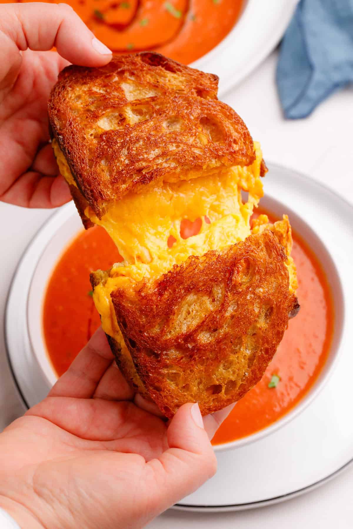 Grilled Cheese Sandwich A Grilled Cheese Sandwich being pulled in half over a bowl of tomato soup.