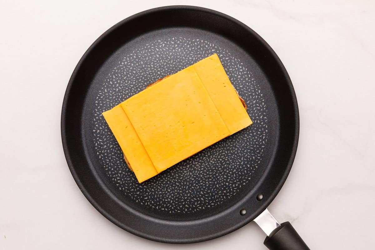 Grilled Cheese Sandwich Cheese on top of bread in a non stick pan.