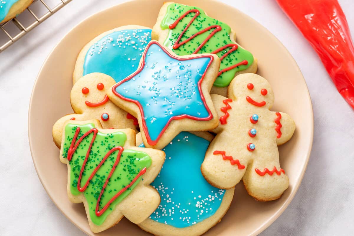 Sugar Cookie Icing A plate of cutout sugar cookies decorated with sugar cookie icing.
