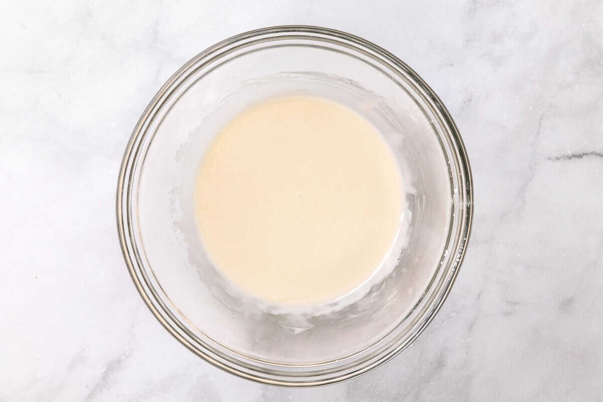 Sugar Cookie Icing Ingredients for Sugar Cookie Icing mixing in a bowl.