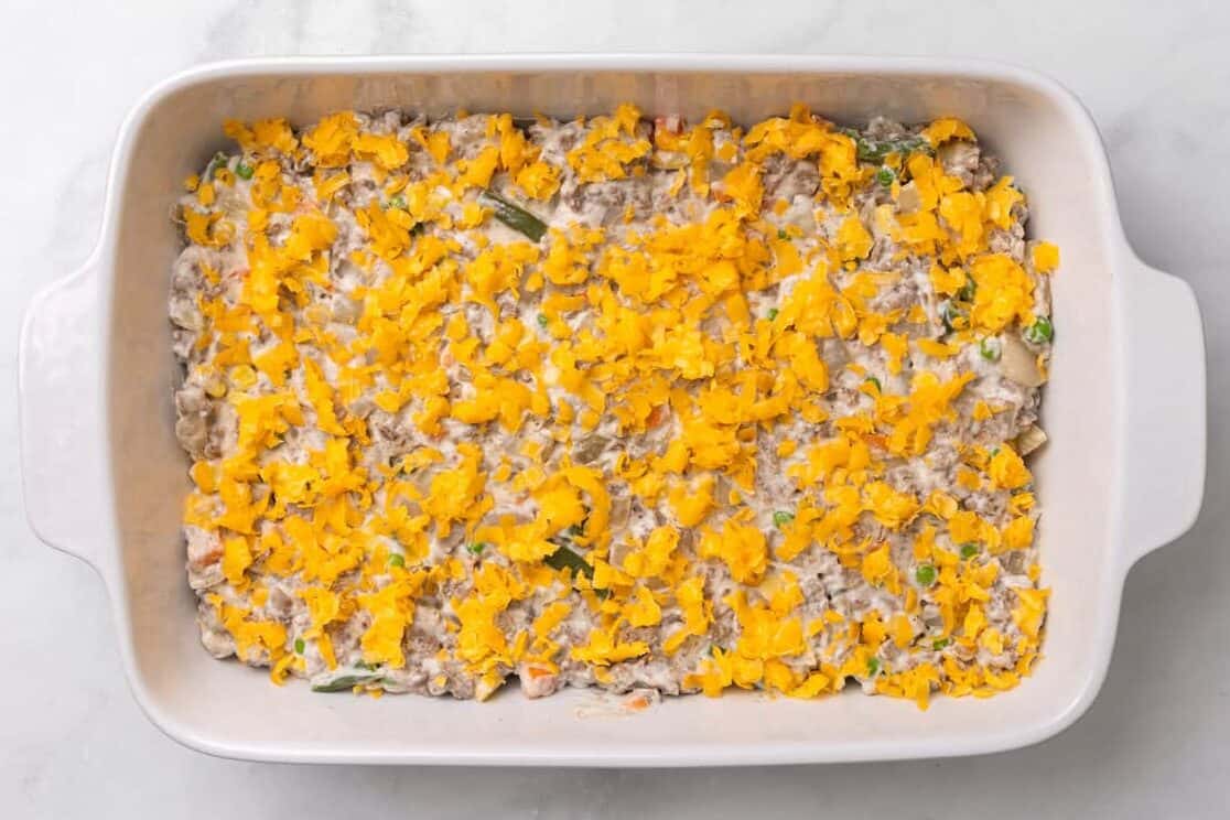 Tater Tot Casserole The mixture for Tater Tot Casserole with cheese on top.