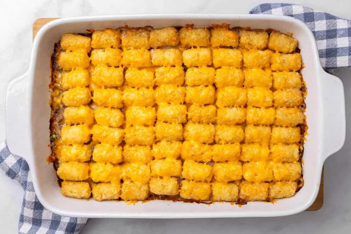 Tater Tot Casserole A finished tater tot casserole sitting on a plaid tea towel.