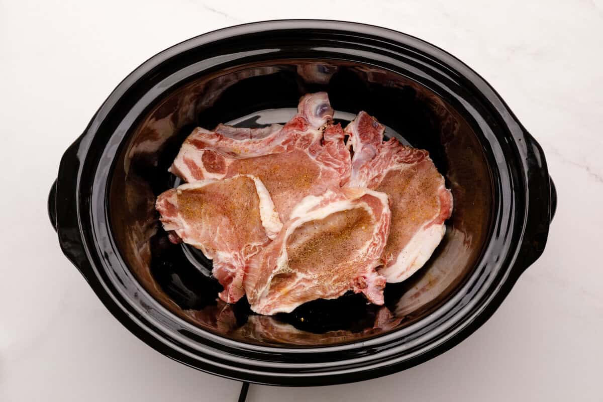 pork chops in a slow cooker pork chops in the bowl of a slow cooker.