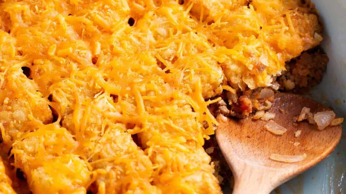 Cheeseburger tater tot casserole with a serving missing.