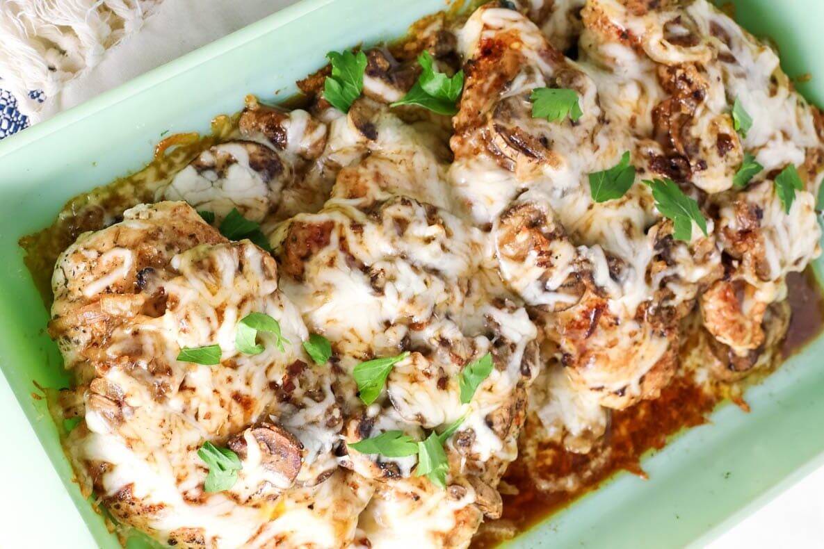 Baked chicken with mushrooms and cheese in a baking dish.