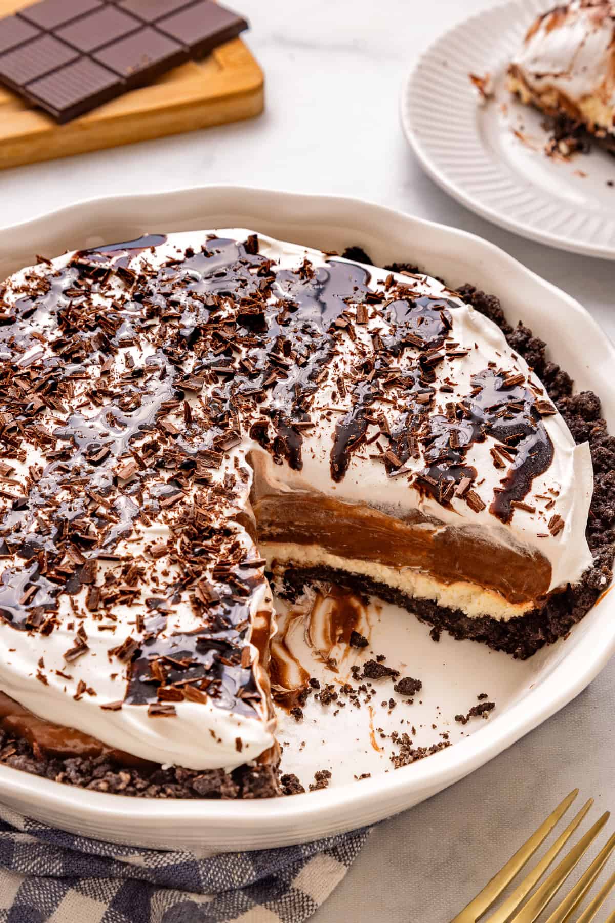 overhead view of mississippi mud pie in a white pie dish on a table with one slice removed