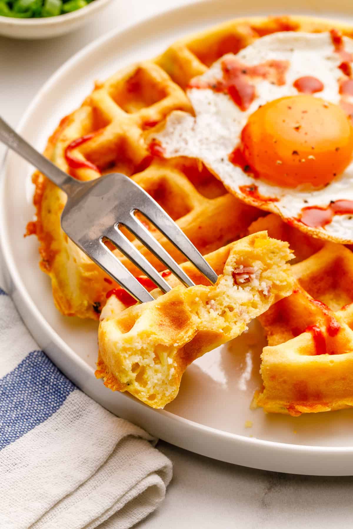savory waffle on a plate showing he inside of a bite