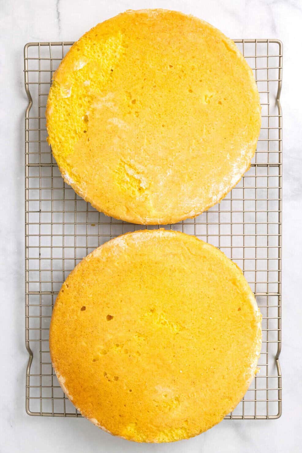 Lemon coconut cake layers baked lemon coconut cakes on a cooling rack.