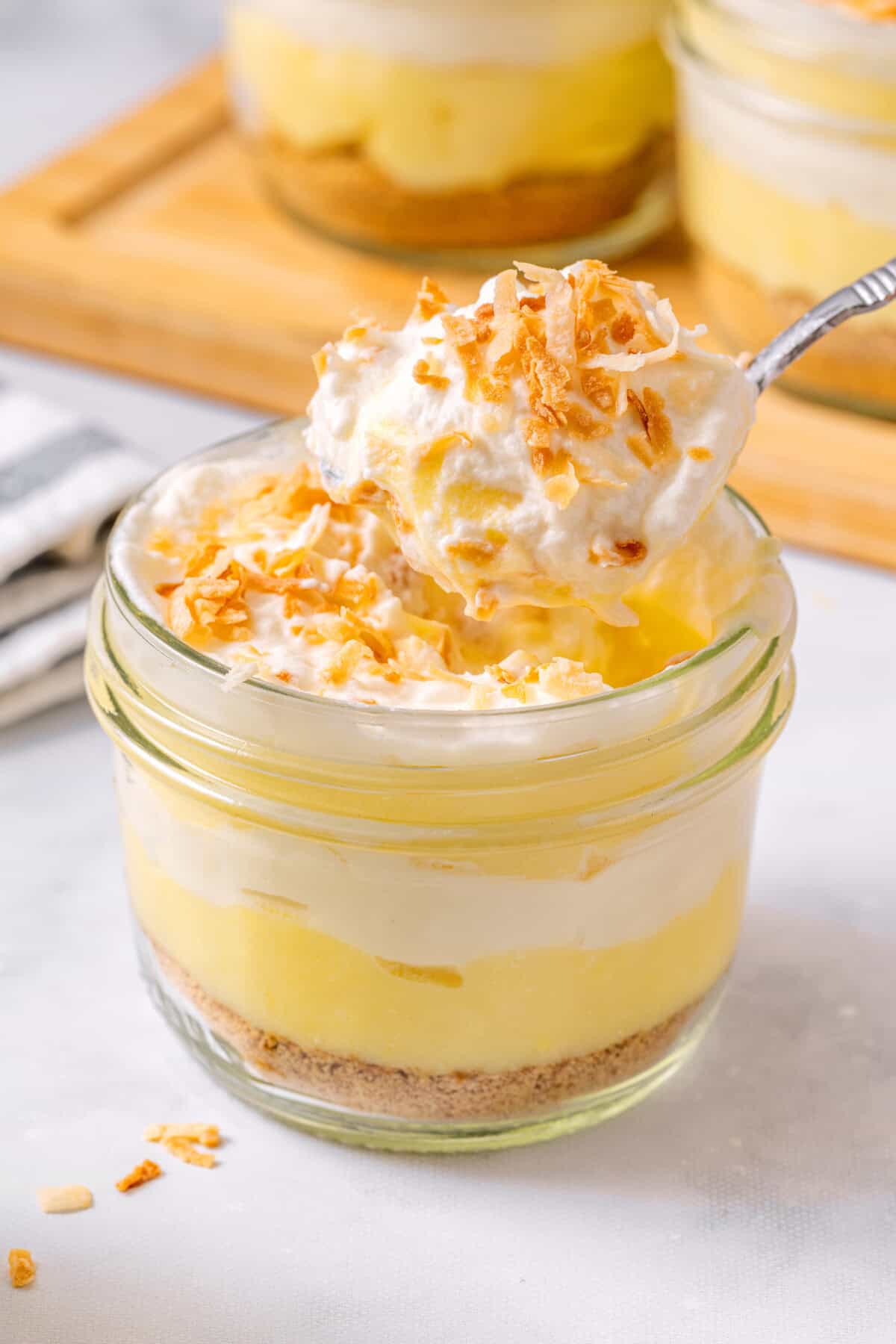 Spoonful of coconut cream pie parfait held over jar