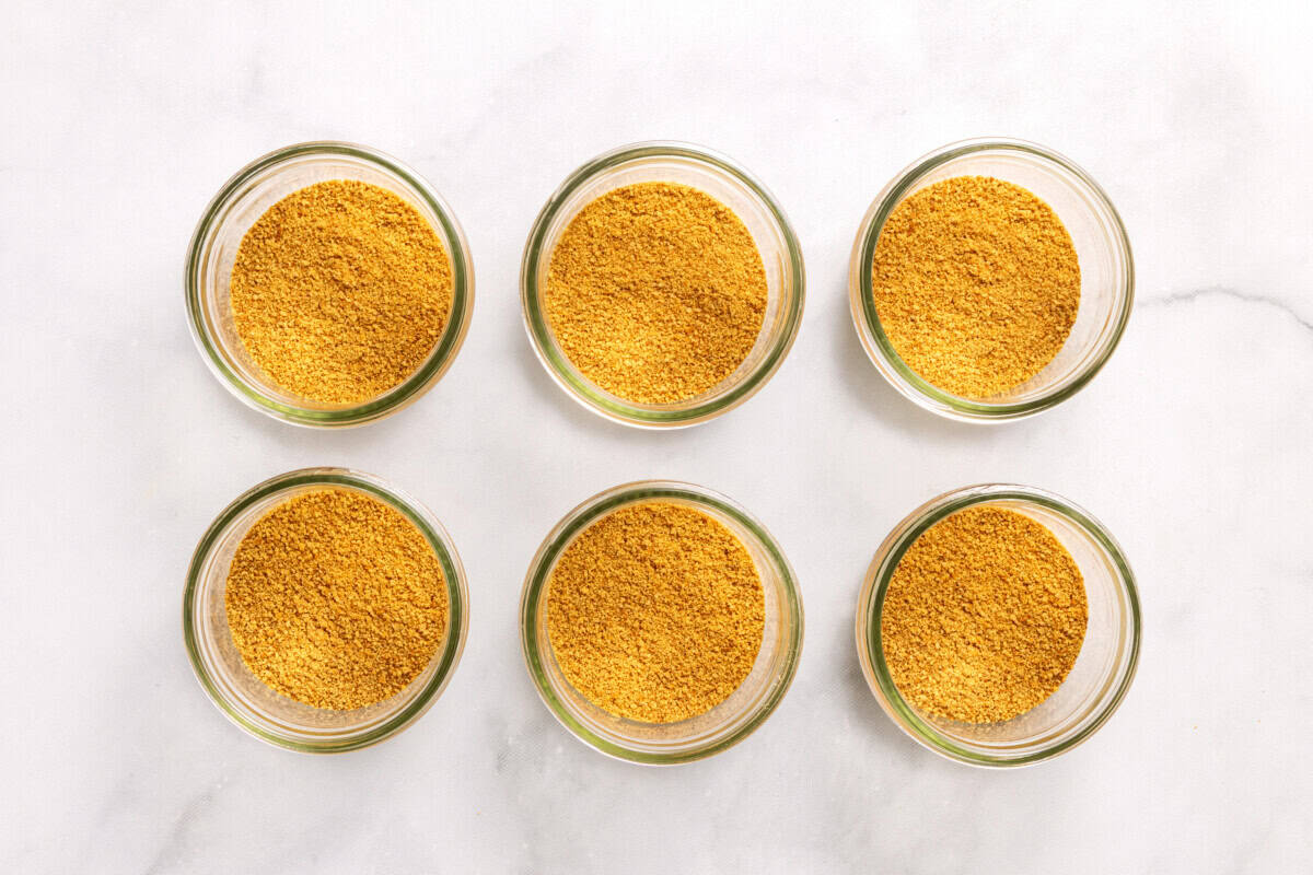 Overhead view of graham cracker crust in bottoms of glass jars